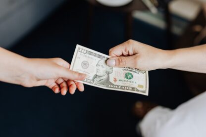 Photo by Karolina Grabowska: Hands exchanging a US $10 bill